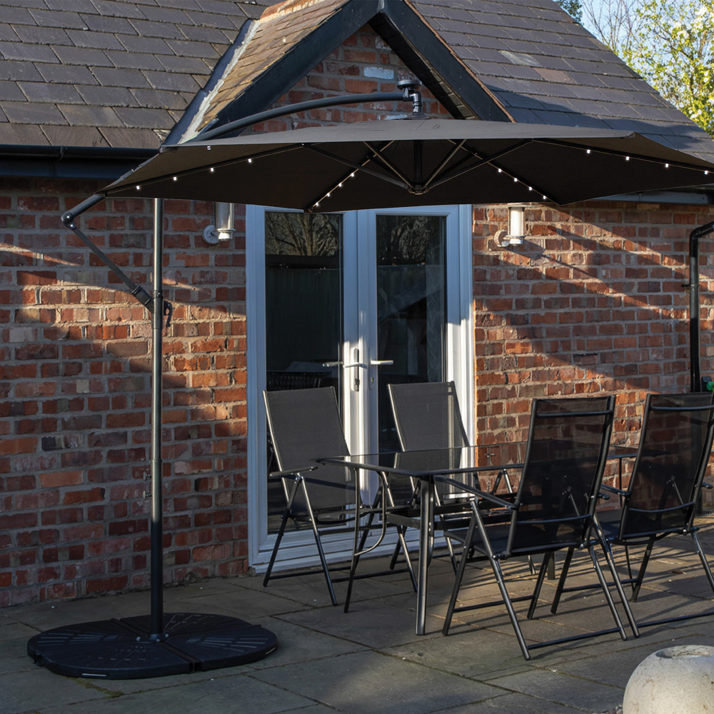 Samuel Alexander 4 Seater Glass Top Outdoor Dining Set with Black Banana Lit Parasol and Base Image 1
