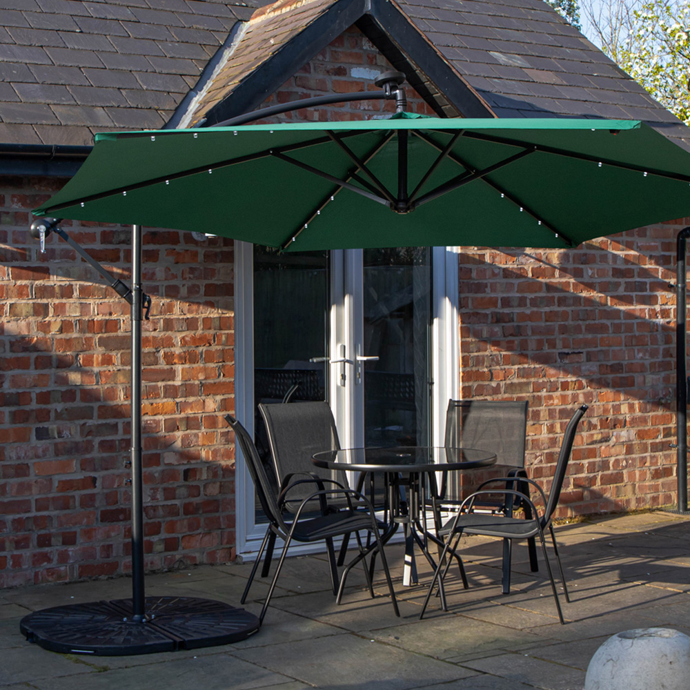 Samuel Alexander 4 Seater Glass Top Stackable Dining Set with Green Banana Lit Parasol and Base Image 1