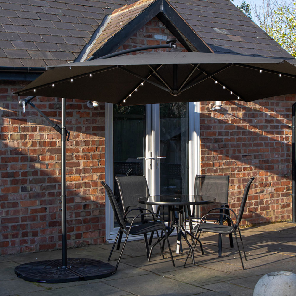 Samuel Alexander 4 Seater Glass Top Stackable Dining Set with Black Banana Lit Parasol and Base Image 1