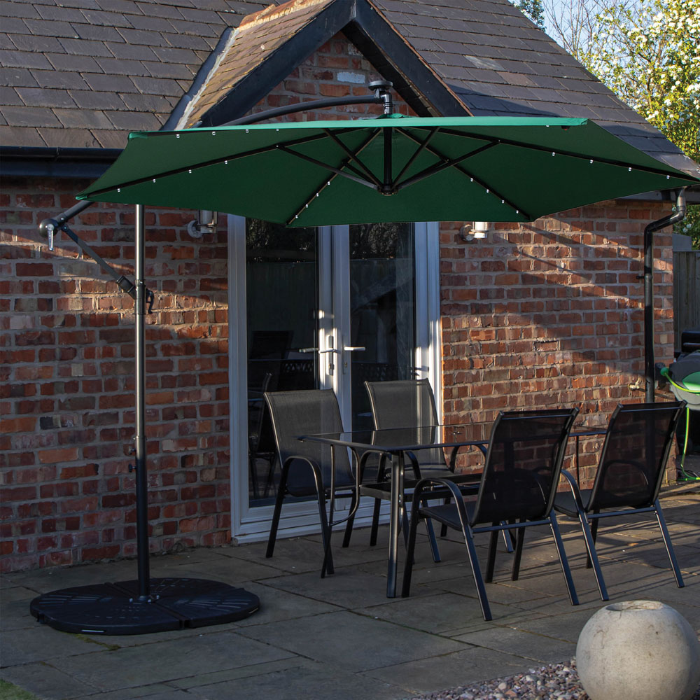 Samuel Alexander 4 Seater Glass Top Outdoor Dining Set with Green Banana Lit Parasol and Base Image 1