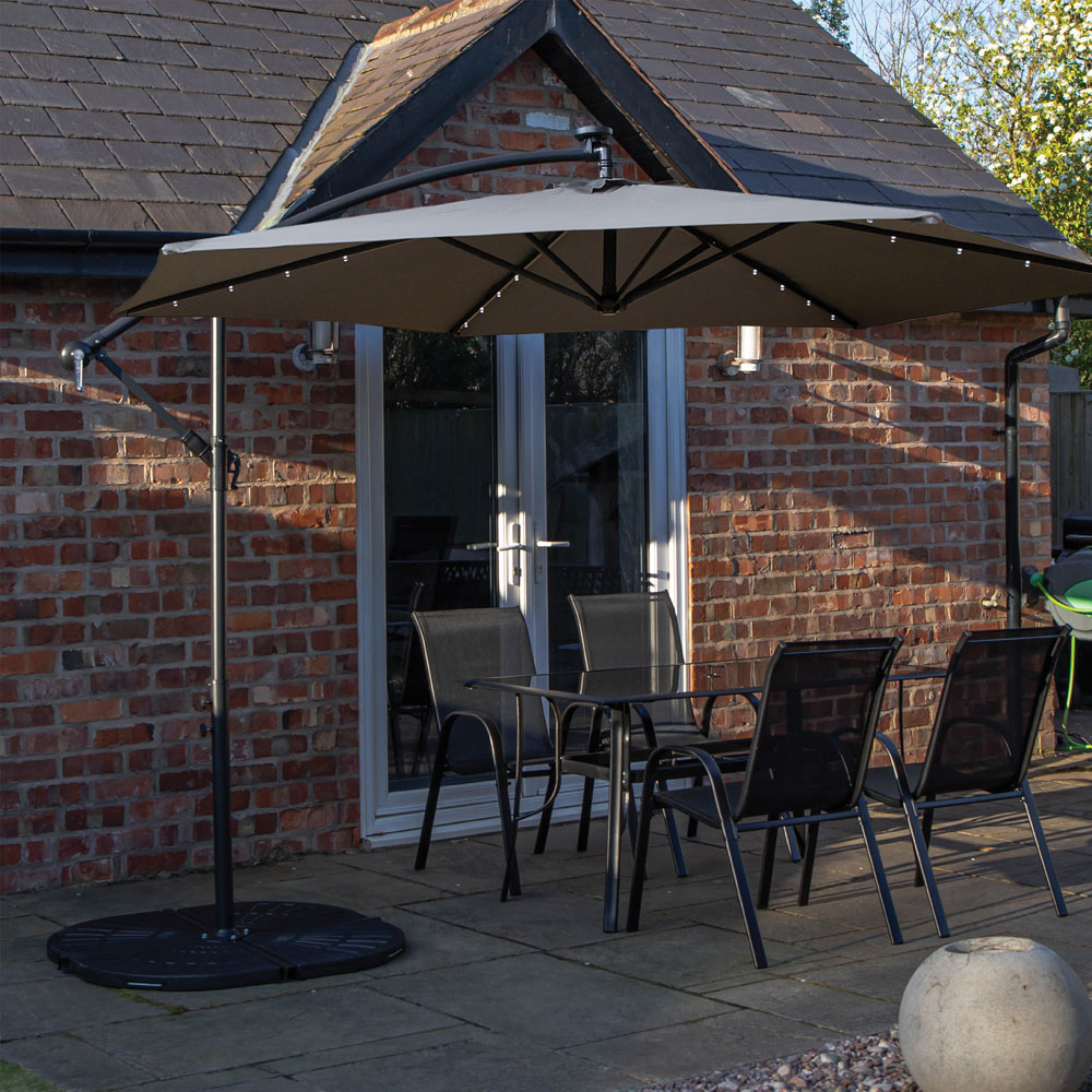Samuel Alexander 4 Seater Glass Top Outdoor Dining Set with Grey Banana Lit Parasol and Base Image 1