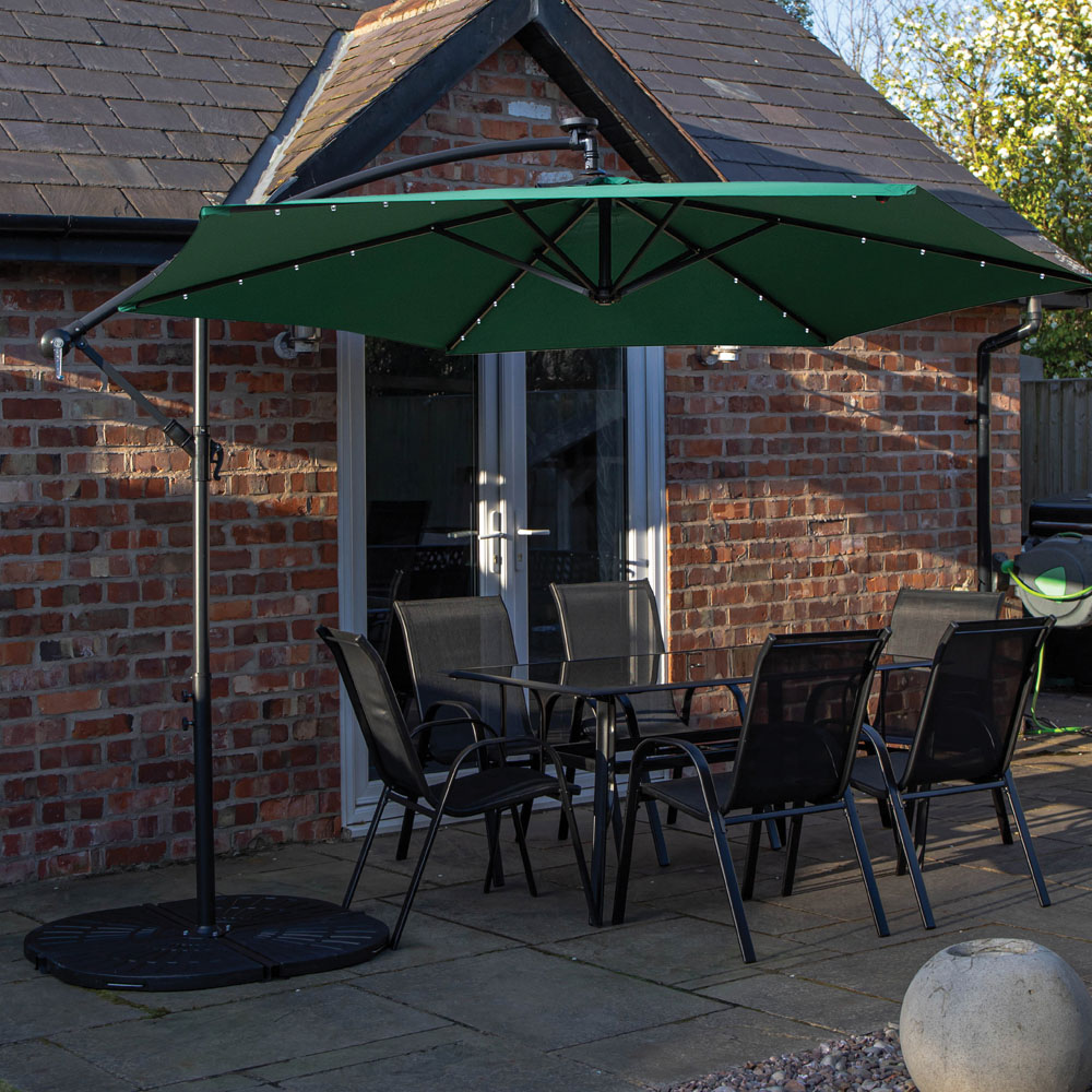 Samuel Alexander 6 Seater Glass Top Outdoor Dining Set with Green Banana Lit Parasol and Base Image 1