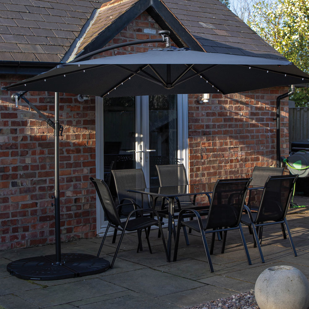 Samuel Alexander 6 Seater Glass Top Outdoor Dining Set with Blue Banana Lit Parasol and Base Image 1