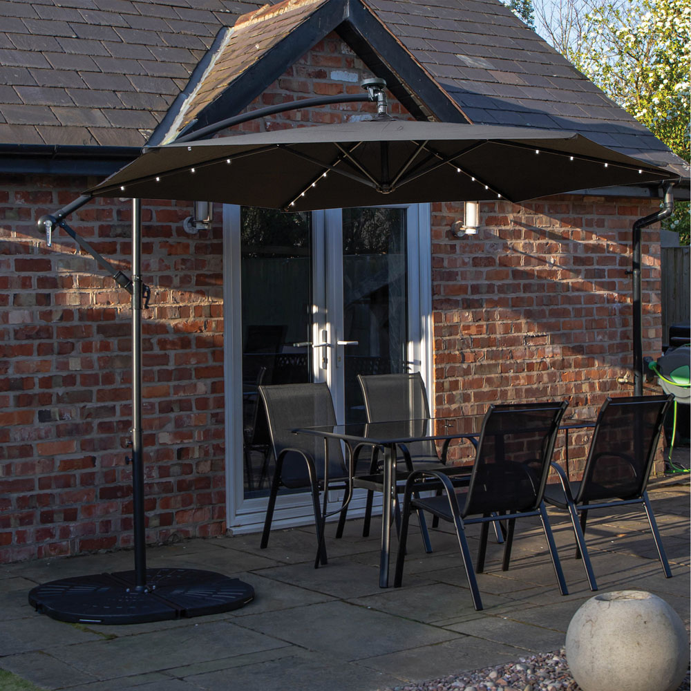 Samuel Alexander 4 Seater Glass Top Outdoor Dining Set with Black Banana Lit Parasol and Base Image 1