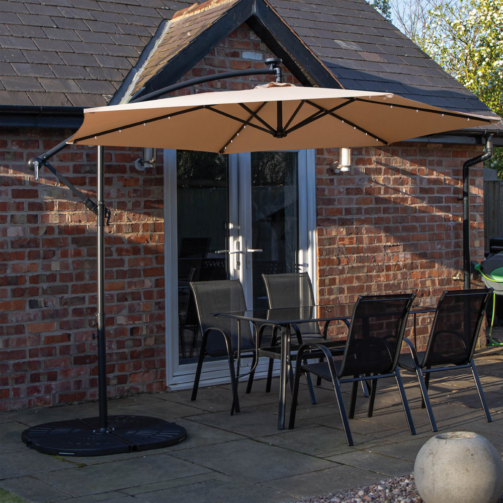 Samuel Alexander 4 Seater Glass Top Outdoor Dining Set with Beige Banana Lit Parasol and Base Image 1